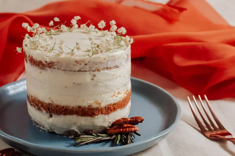 Naken kake med små hvite blomster på blått fat